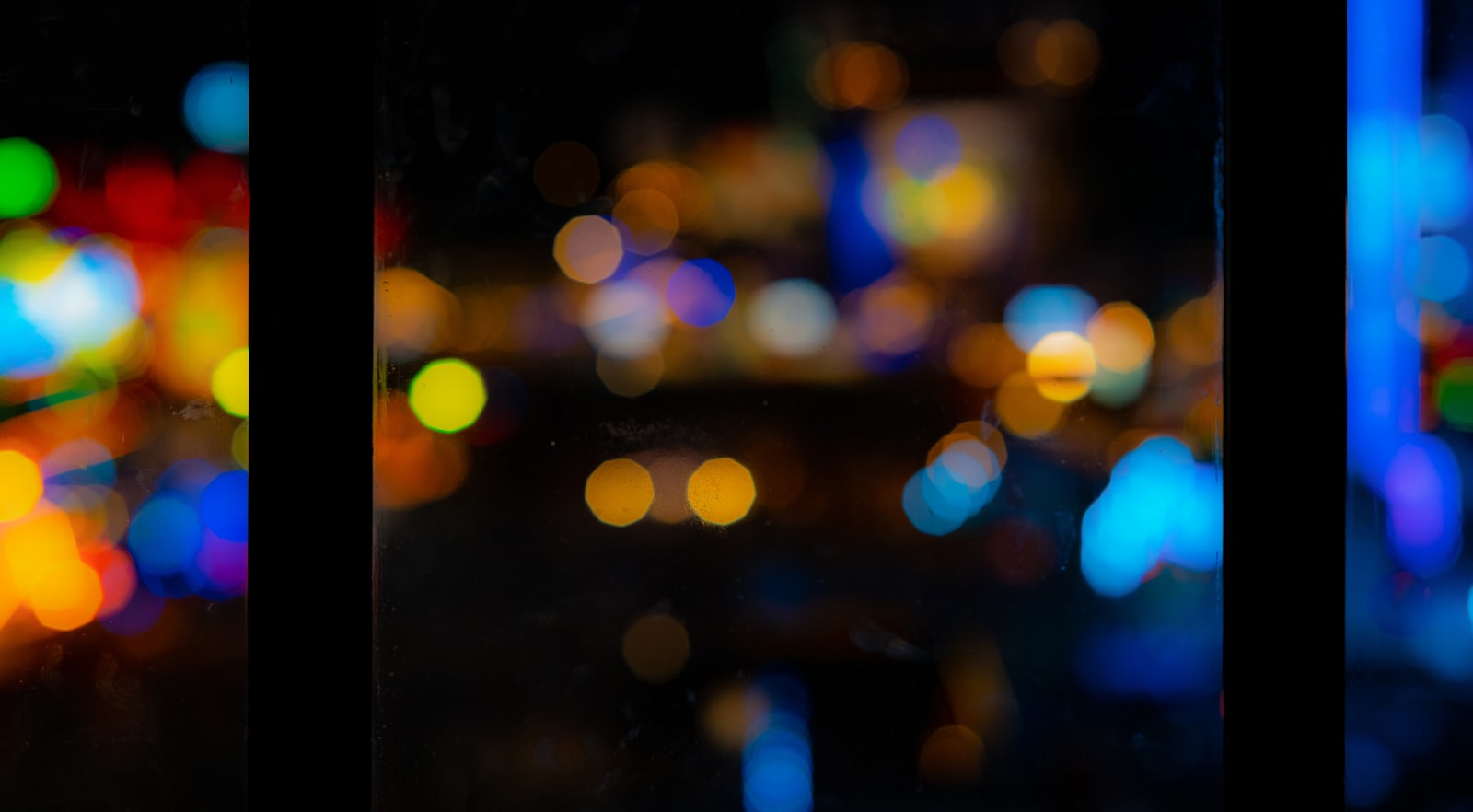 Colorful bokeh lights blurred through a night window